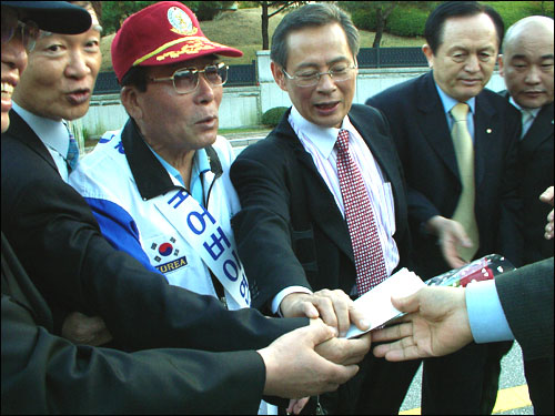 서석구 변호사, 이강성 부회장,  홍정식 단장, 등이 국정원간부에게 서신과 장미꽃을 전달하고 있다. 